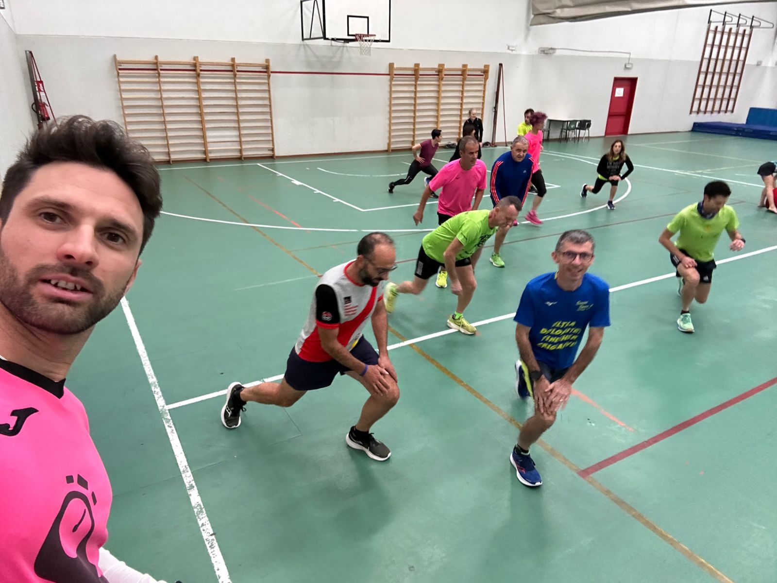 Runners in palestra durante affondi ed esercizi di mobilità nella sessione del giovedì