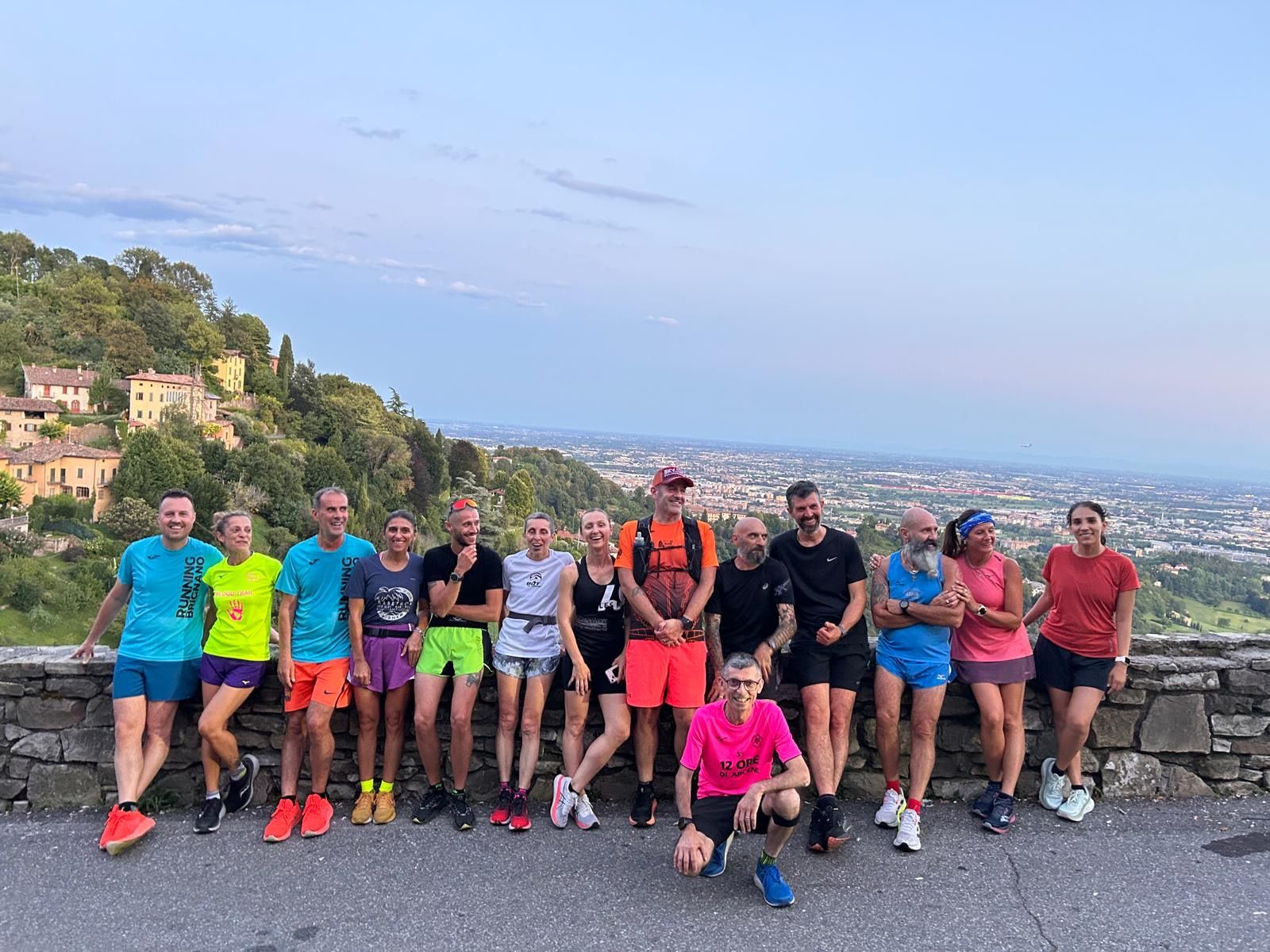 Gruppo Let's Run in posa su una terrazza panoramica dopo una corsa in collina al tramonto